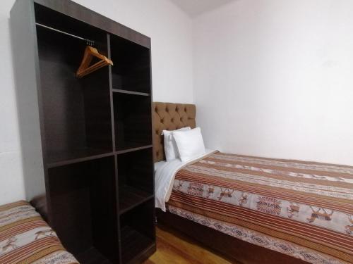 a small bedroom with a bed and a book shelf at Magnolia Andina in Cusco