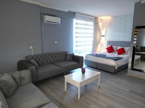 a living room with a couch and a bed at Akman City Hotel in Kusadası