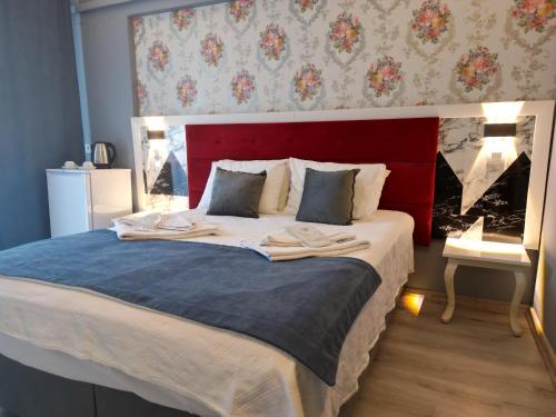 a bedroom with a large bed with a red headboard at Akman City Hotel in Kusadası