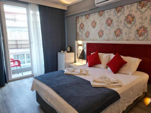 a bedroom with a bed with two slippers on it at Akman City Hotel in Kusadası