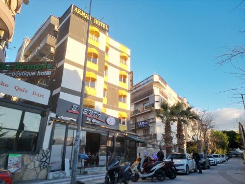 a building on the side of a street with parked cars at Akman City Hotel in Kusadası