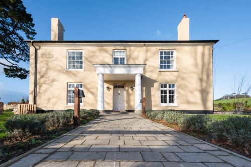 an old stone house with a driveway at Cofford Farm in Exeter