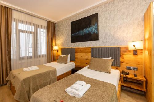Una habitación de hotel con dos camas y un televisor. en Double DD Hotel, en Estambul