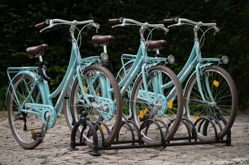 a group of three bikes parked on a rack at Grand Hôtel Des Templiers, Piscine & Spa in Reims