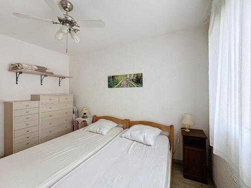 une chambre avec deux lits et un ventilateur de plafond dans l'établissement 3548-Appartement à 100m de la plage, à Argelès-sur-Mer