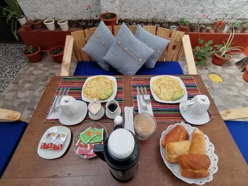 a breakfast table with eggs and bread on it at Magnolia Andina in Cusco