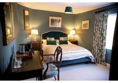 a bedroom with a bed and a desk and a table with a chair at The Martins Arms in Nottingham