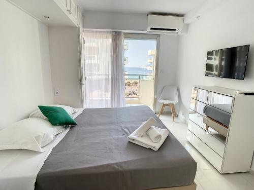une chambre blanche avec un grand lit avec une fenêtre dans l'établissement Appartements derrière Croisette, à Cannes