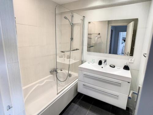 une salle de bain blanche avec un lavabo et une douche dans l'établissement Appartements derrière Croisette, à Cannes