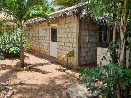 a building with a white door and a palm tree at Akwaba Chez les Filles in Mahajanga
