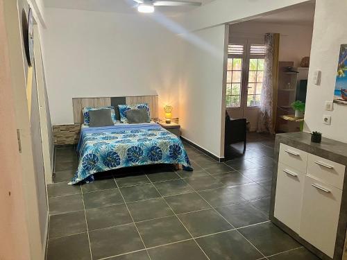 Un dormitorio con una cama con una manta azul encima. en Tilys house, en Capesterre-Belle-Eau