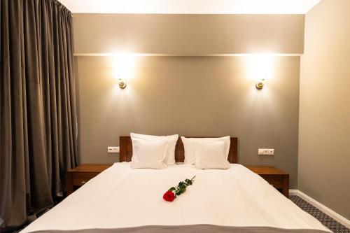 a bedroom with a bed with two roses on it at Aria by Brilliant in Zalău