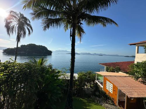 a view of the water from a house with palm trees at Cabana do Mar in Angra dos Reis