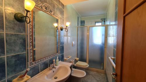 Un baño con lavabo, inodoro y espejo. en Casa Vacanza GLI ULIVI, en Santa Cesarea Terme