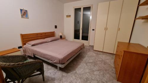 Un dormitorio con una cama y una silla dentro. en Casa Vacanza GLI ULIVI, en Santa Cesarea Terme
