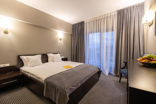 a hotel room with a bed and a window at Aria by Brilliant in Zalău