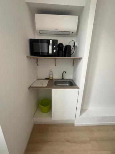 a small kitchen with a sink and a microwave at Résidence Appartement Adonis in Nice