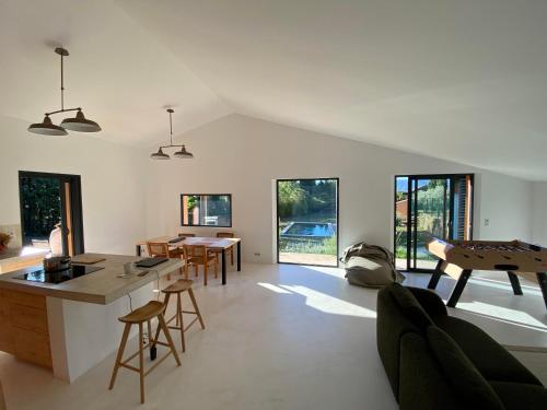 Il comprend une cuisine et un salon avec des tables et des chaises. dans l'établissement Le Jardin des Graminées, à Cabrières-dʼAvignon
