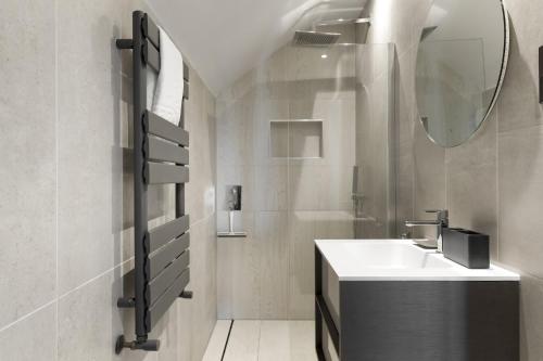 a white bathroom with a sink and a mirror at Bright & Modern Townhouse Private Parking in Saint Columb Minor