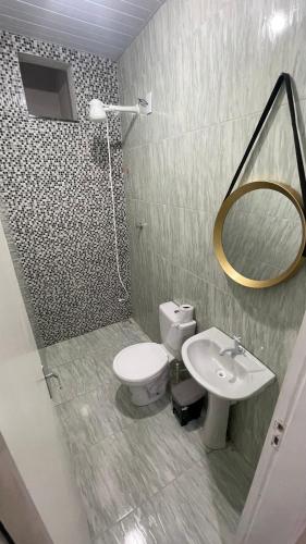 ein Badezimmer mit Toilette, Waschbecken und Spiegel in der Unterkunft Morilar AP 01 in Tianguá