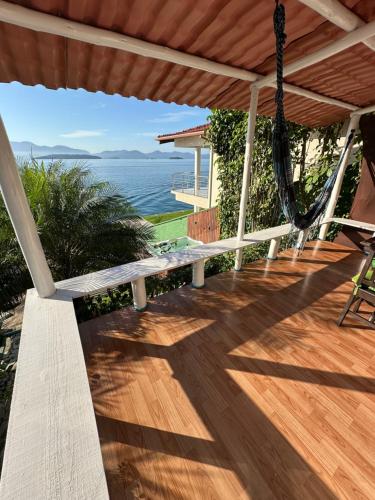 a porch with a hammock and a view of the ocean at Cabana do Mar in Angra dos Reis