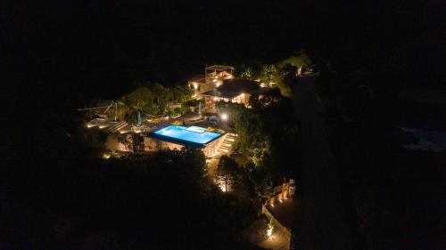 an aerial view of a house with a swimming pool at night at VILLA AMIRA Porto Cervo con vista Mozzafiato sul Mare,Piscina Privata,WELLNESS & SPA in Liscia di Vacca