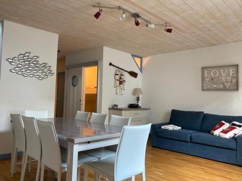 une salle à manger avec une table et un canapé bleu dans l'établissement Cour du Temple - vieux Port 6 pers - 3 étoiles, à La Rochelle