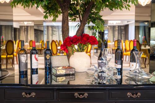 a table with bottles of wine and flowers on it at Aria by Brilliant in Zalău