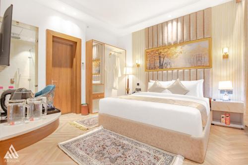 a bedroom with a large white bed and a bathroom at Arison Luxury in Srinagar