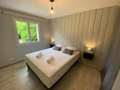 une chambre avec un grand lit avec deux oreillers dessus dans l'établissement Villa OLYMPE & son T2, à Andernos-les-Bains