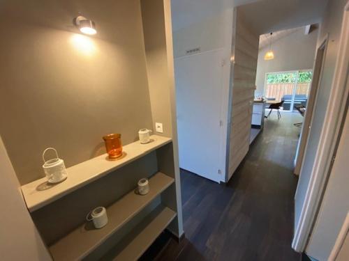 une chambre avec une étagère et des tasses dessus dans l'établissement Villa OLYMPE & son T2, à Andernos-les-Bains