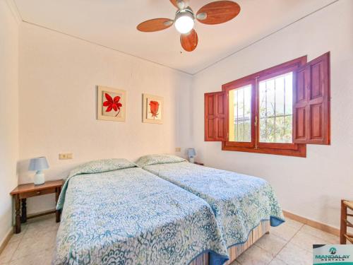a bedroom with a bed and a ceiling fan at Casa Fortunata in Benitachell