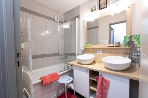 a bathroom with two sinks and a mirror at Appartement Bois de Marie in Sers