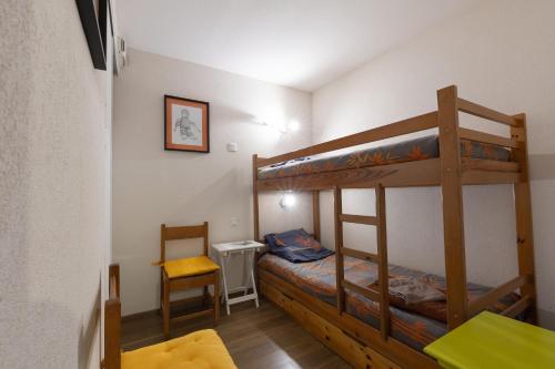 a bedroom with two bunk beds and a chair at Appartement Bois de Marie in Sers