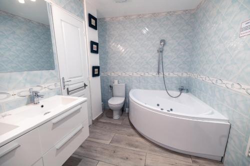 a bathroom with a tub and a sink and a toilet at Couvent des Carmes in Narbonne