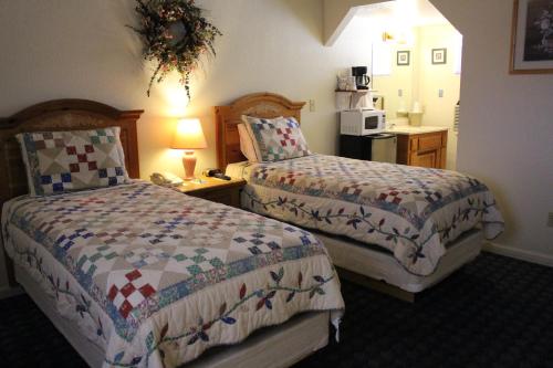 a hotel room with two beds and a microwave at Barewood Inn & Suites in Wofford Heights