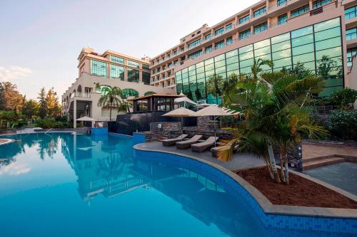 a hotel with a swimming pool in front of a building at Kigali Marriott Hotel in Kigali