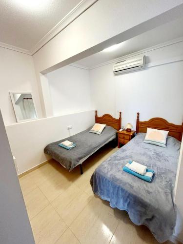two twin beds in a room with a window at Monte Mar Apartment in Gran Alacant
