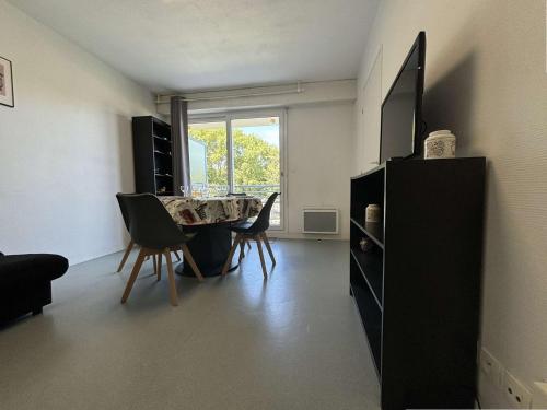 un salon avec une table et des chaises et une fenêtre dans l'établissement Appt 2 pièces LA ROCHELLE - LR220-021, à La Rochelle