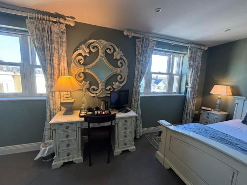 a bedroom with a desk with a computer and a bed at Horse & Hound in Delgany