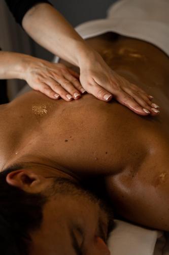 a man getting a back massage on his back at Coco Boutique Hotel & Spa in Karpacz