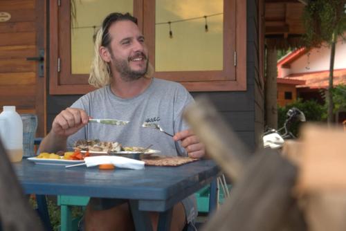 a man sitting at a table with a plate of food at Tomorrowland Beach Villas in Tangalle