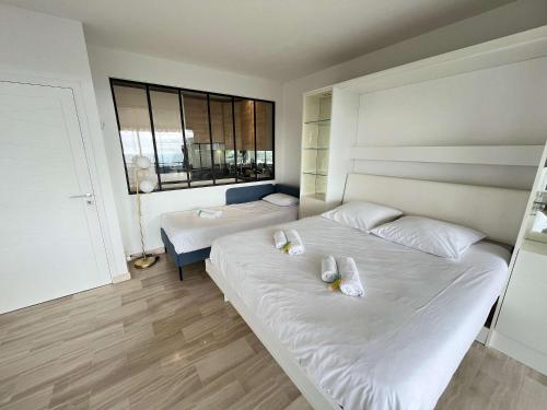 une chambre avec deux lits et une fenêtre dans l'établissement A023-Magnifique vue mer panoramique, à Vallauris