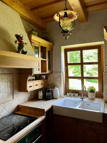 a kitchen with a sink and a window at Chalupa pri Ukoch, welness in Matěk
