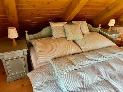 a bed in a room with a wooden ceiling at Chalupa pri Ukoch, welness in Matěk