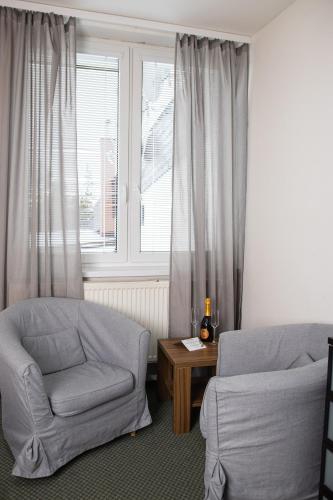 a living room with a chair and a window at Penzión Furkotka in Štrbské Pleso