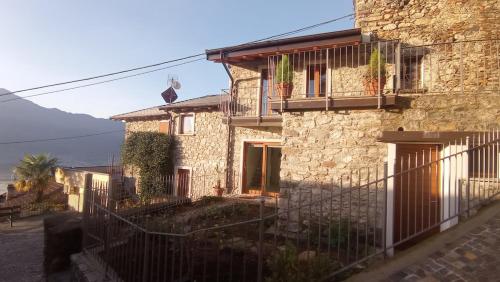 a stone house with a fence in front of it at Die Weinrose - Natura Lago Monti in Montemezzo