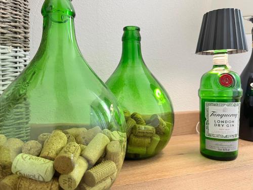 two green bottles sitting on top of a table at Die Weinrose - Natura Lago Monti in Montemezzo