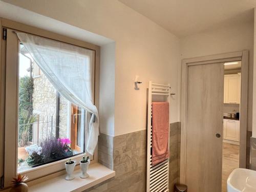 a bathroom with a window and a sink at Die Weinrose - Natura Lago Monti in Montemezzo