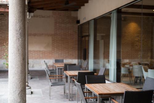 a row of wooden tables and chairs in a building at Castilla Termal Olmedo in Olmedo